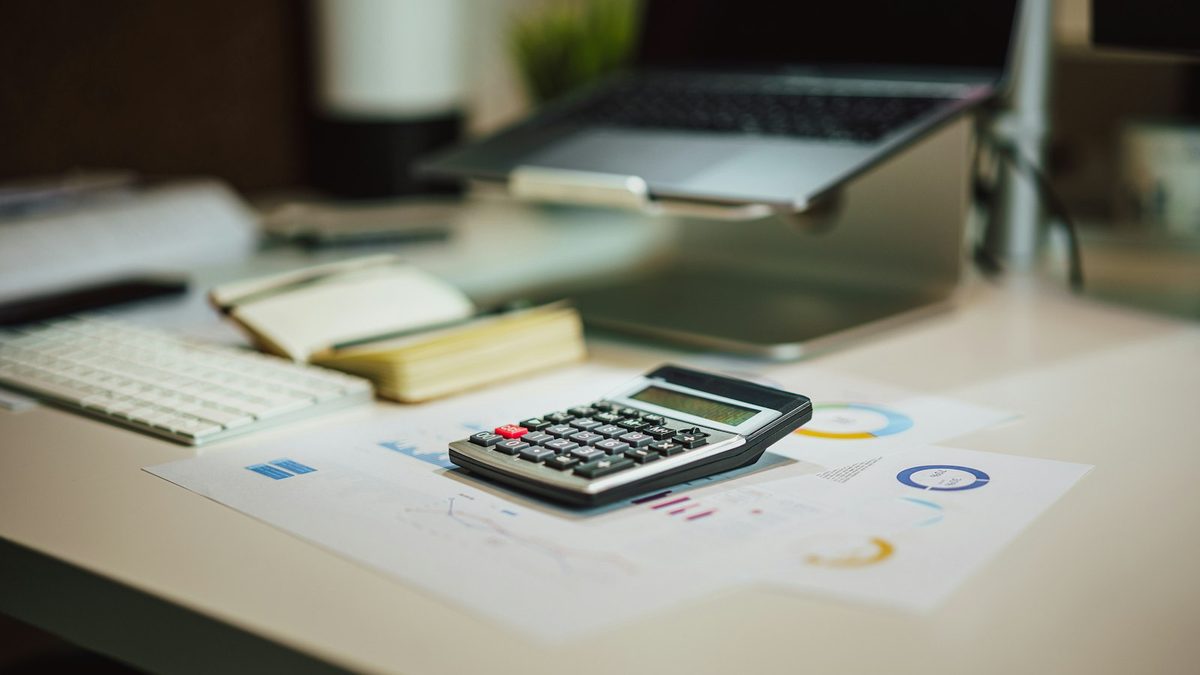 Calculatrice posée sur un bureau avec des documents et un carnet