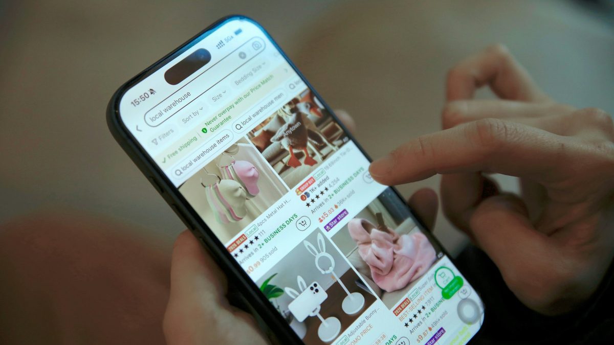 Main faisant défiler une boutique en ligne sur un smartphone